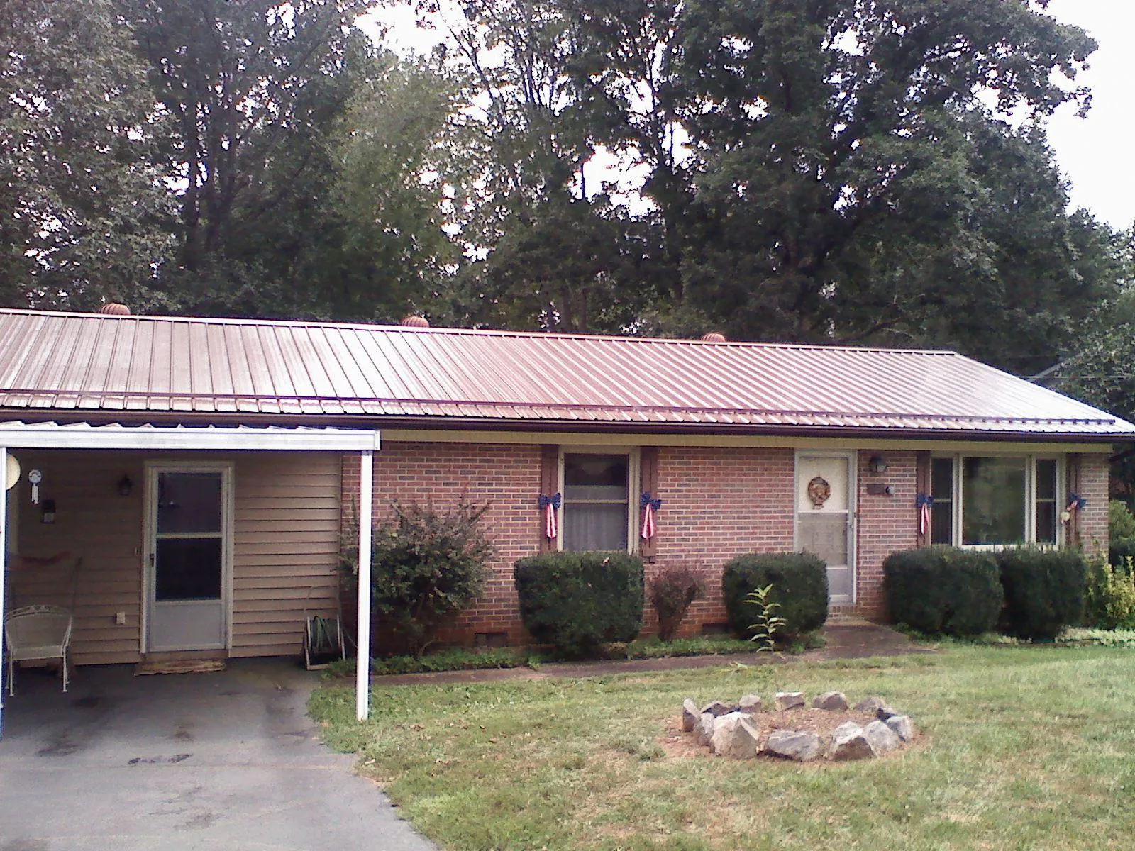 Bronze metal roof and carport on a brick ranch home — Roof Repair work by our crew in Pacolet Mills